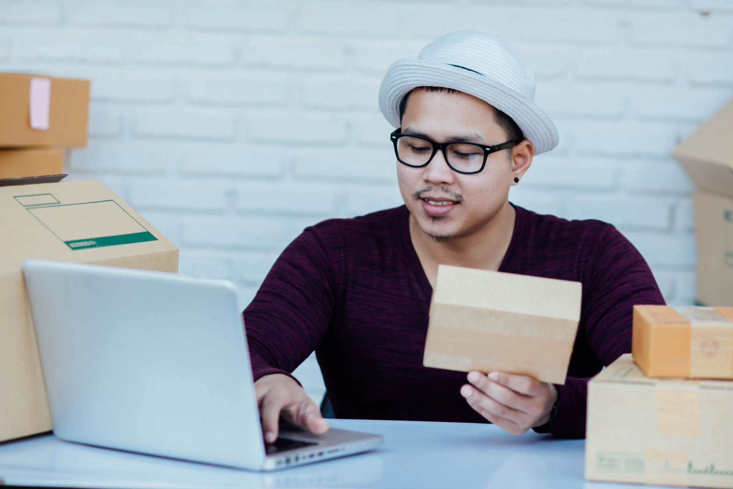 Delivery service working with papers among parcels at table Delivery service working with papers among parcels at table